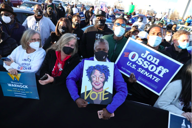 Los partidarios miran las campañas del presidente electo Joe Biden.