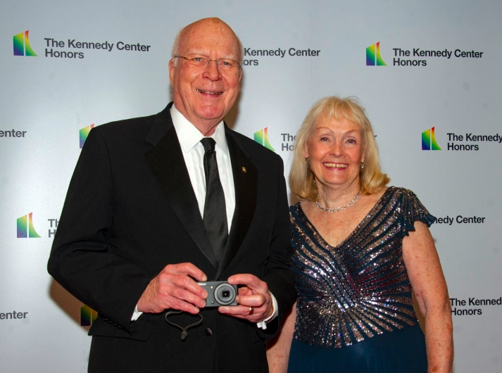 El senador Patrick Leahy (demócrata de Vermont) toma una foto de los fotógrafos cuando él y su esposa, Marcelle, llegan a la cena formal del artista en 2018.