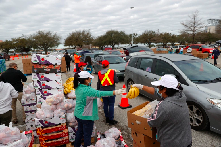 Los voluntarios se preparan para cargar alimentos en los automóviles durante la distribución de alimentos del Houston Food Bank en el NRG Stadium el 21 de febrero de 2021 en Houston, Texas. Miles de personas hicieron fila para recibir alimentos y agua en un sitio de distribución masiva para los residentes de Houston que aún no tienen agua corriente ni electricidad después de la tormenta invernal Uri.