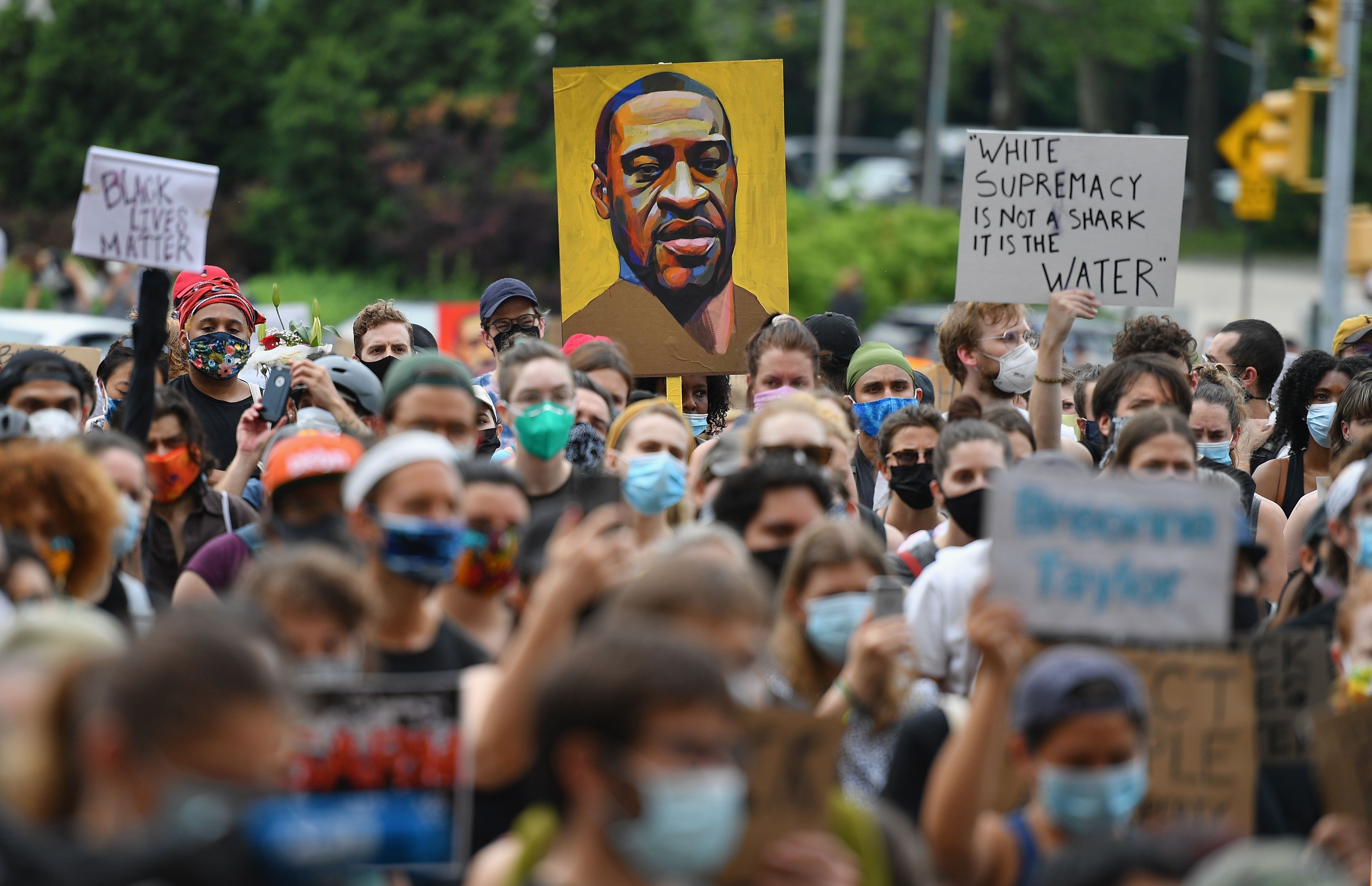 Un manifestante sostiene un retrato de George Floyd durante una manifestación de "Black Lives Matter" frente a la Biblioteca de Brooklyn y Grand Army Plaza el 5 de junio de 2020 en Brooklyn, Nueva York.