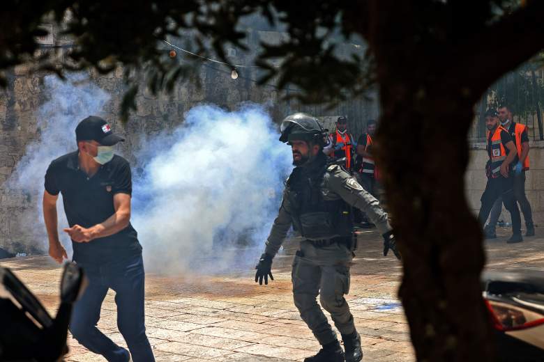 Los palestinos corren para refugiarse de los gases lacrimógenos lanzados por las fuerzas de seguridad israelíes en la Ciudad Vieja de Jerusalén el 10 de mayo de 2021.