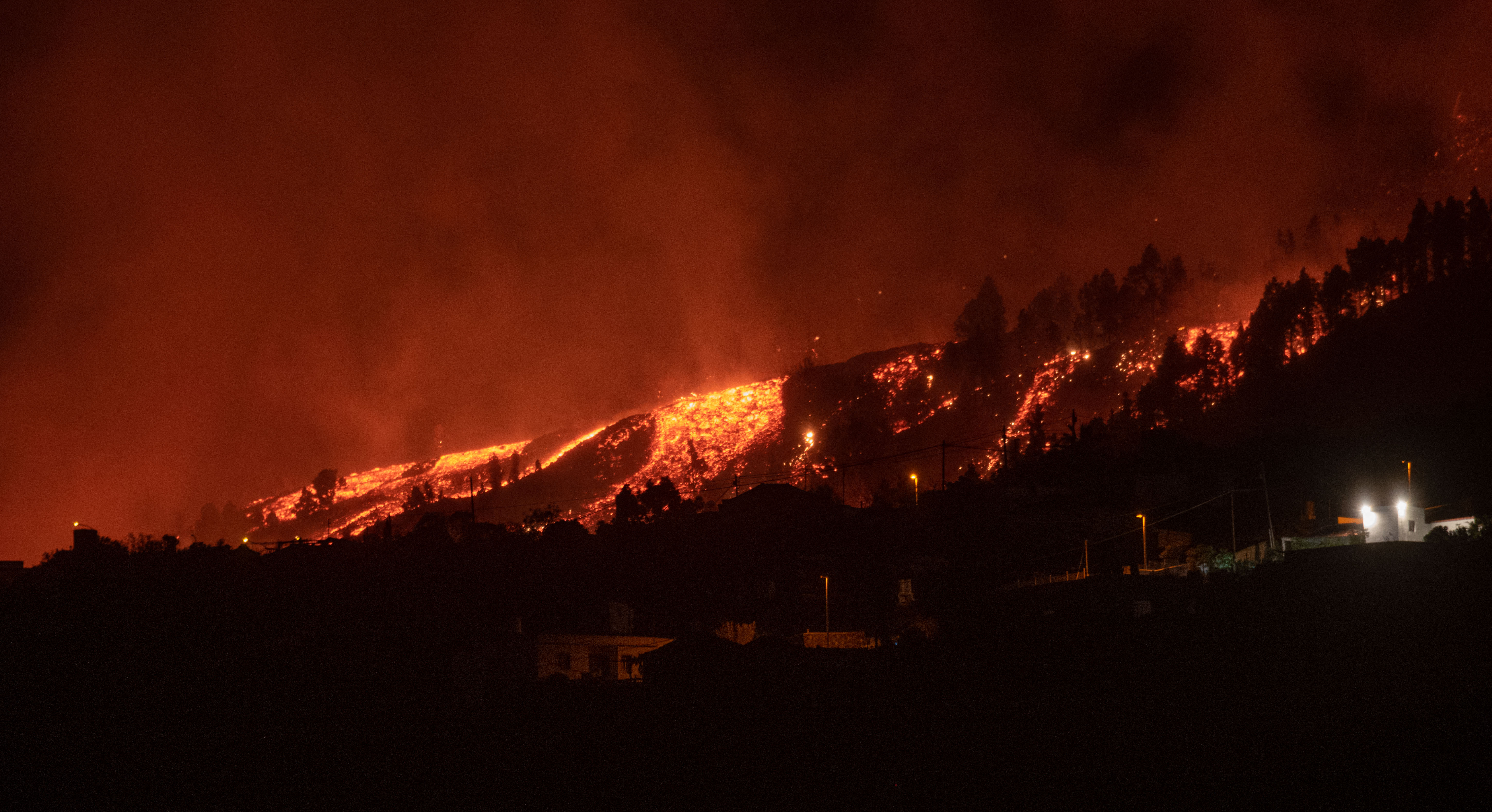 Los flujos de lava se acercan a las casas cuando el Monte Cumbre Vieja entra en erupción en El Paso, arrojando columnas de humo, ceniza y lava como se ve desde Los Llanos de Aridane en la isla canaria de La Palma, el 19 de septiembre de 2021.