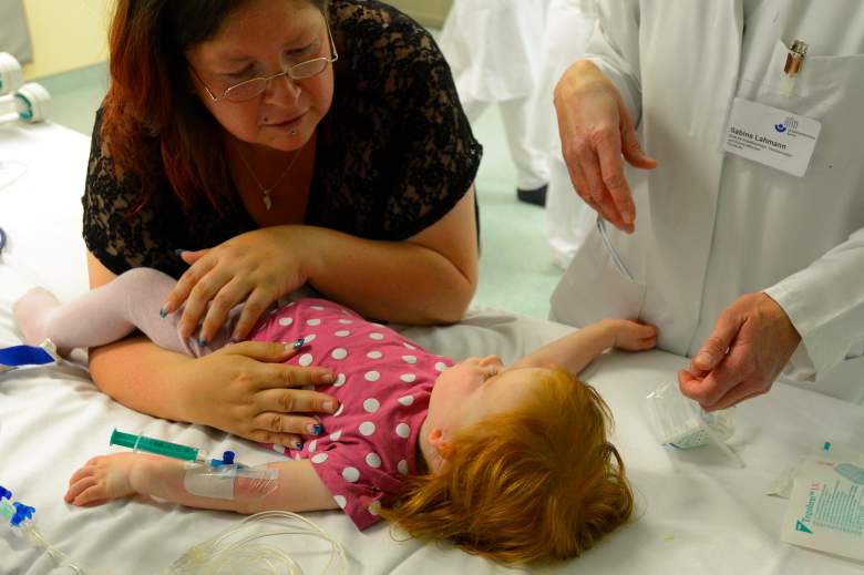 Una madre consuela a Laura Loreen, una de sus dos hijas gemelas, antes de que ambas niñas fueran operadas de oído en el hospital Unfallkrankenhaus Berlin (UKB) en el distrito de Marzahn el 17 de junio de 2013 en Berlín, Alemania.