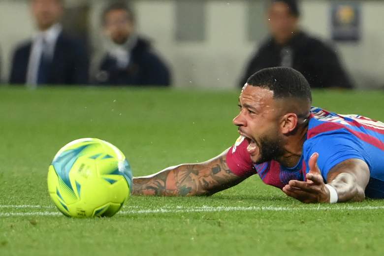 El delantero holandés del Barcelona Memphis Depay reacciona en el suelo durante el partido de fútbol de la liga española entre el FC Barcelona y el RC Celta de Vigo en el estadio Camp Nou de Barcelona el 10 de mayo de 2022.