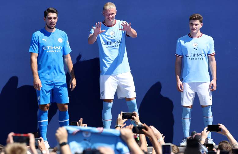 El portero alemán del Manchester City Stefan Ortega (L), el delantero noruego del Manchester City Erling Haaland (C) y el delantero argentino del Manchester City Julian Alvarez participan en un evento de presentación de jugadores del club de fútbol del Manchester City en el estadio Etihad en Manchester, noroeste de Inglaterra en julio 10, 2022, para presentar los nuevos fichajes de verano del club a los aficionados.