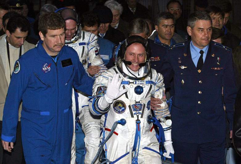 US astronaut Edward Michael Fincke (C) escorted by Russian officers as Dutch ESA astronaut Andre Kuipers (L) follows him during a farewell ceremony at the launch pad of Baikonur cosmodrome, 19 April 2004.