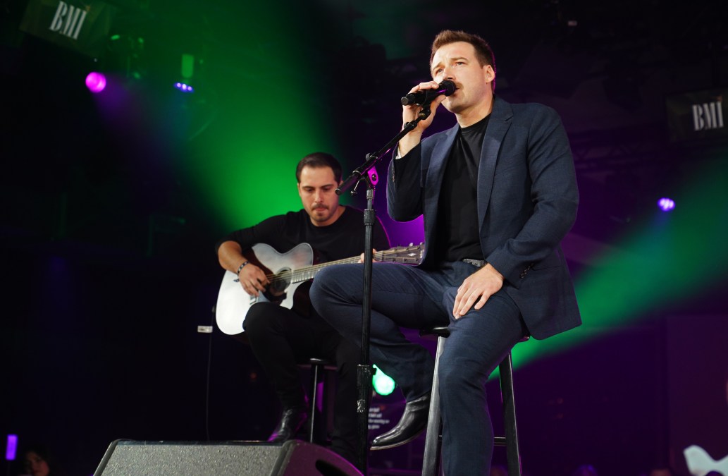 Morgan Wallen singing into a microphone