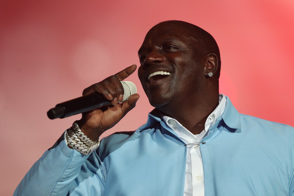 Akon sings into a microphone