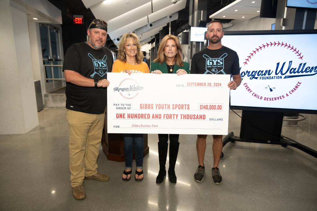 Members of the Morgan Wallen Foundation hold up a large check